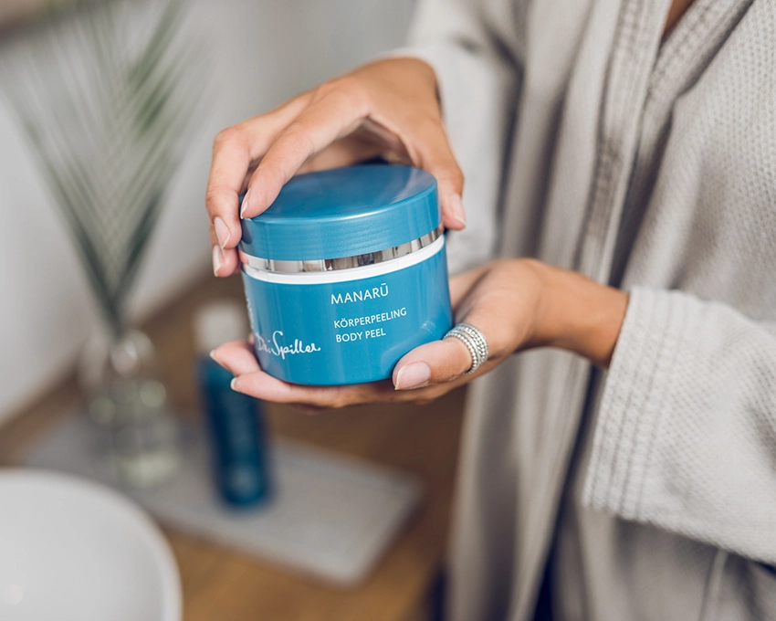 Manaru body scrub in hand of woman in bathroom