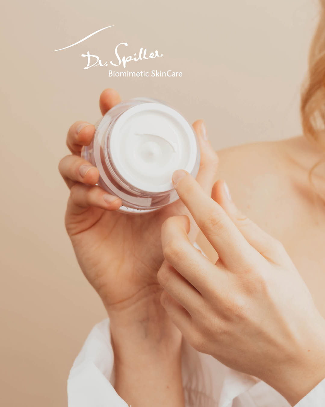 Frau hält offenen Tiegel einer Gesichtspflege in die Hände