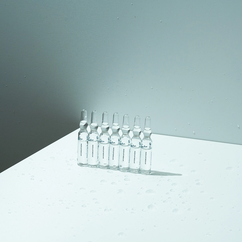 Several ampoules stand on a table with a bluish background