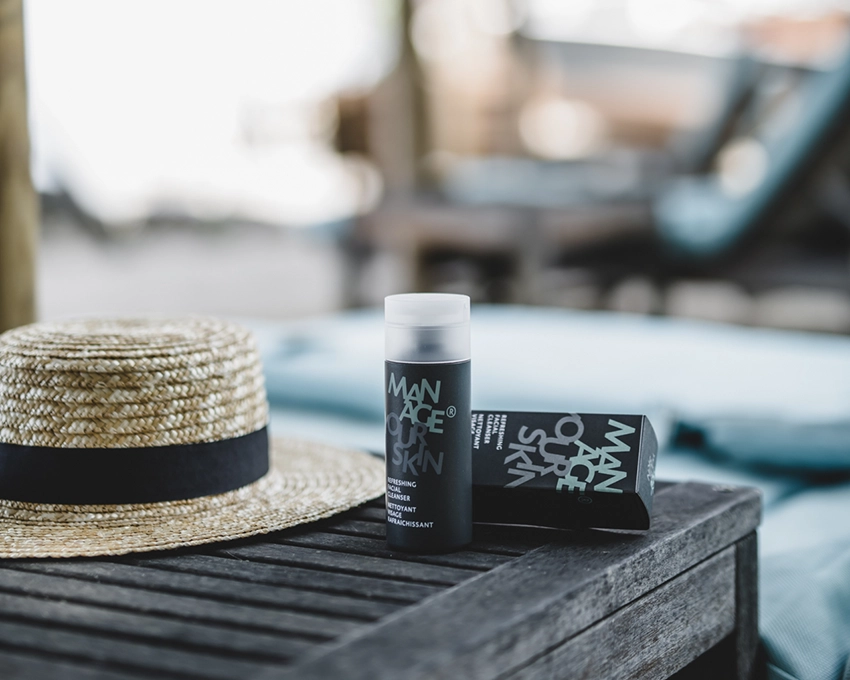 Refreshing Facial Cleanser bottle & packaging on a wooden table at a vacation spot