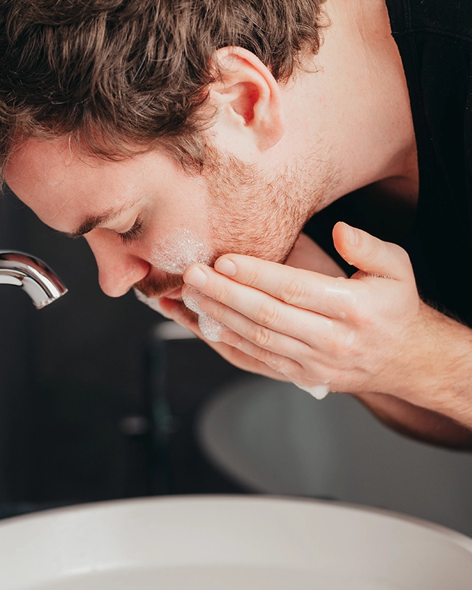 Man washes his face with the Refreshing Facial Cleanser