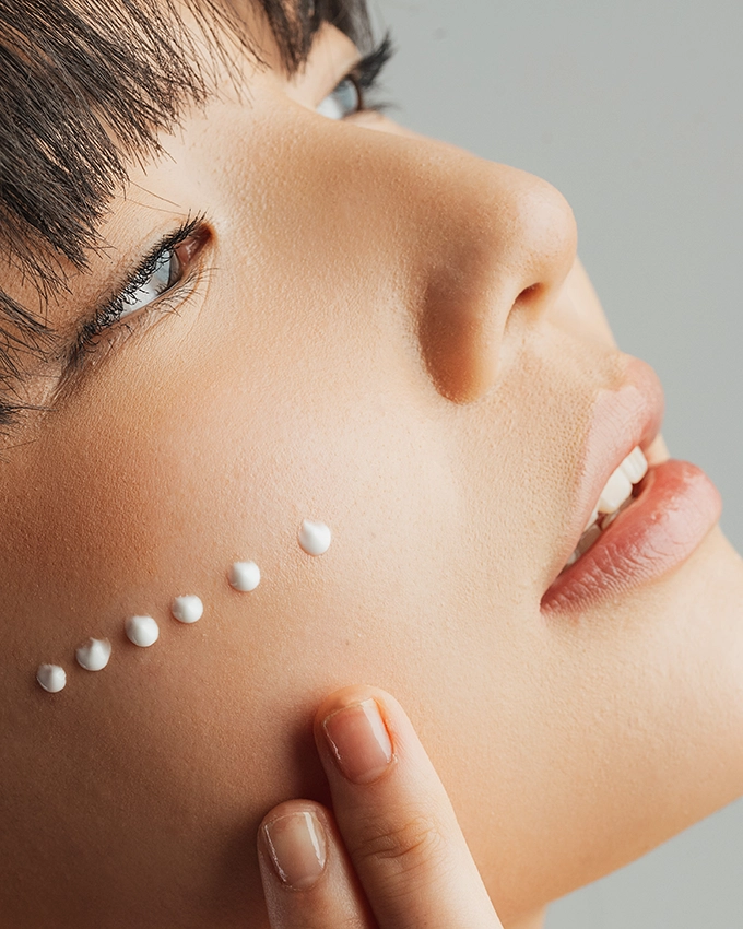 Serum is applied selectively to the woman's cheek