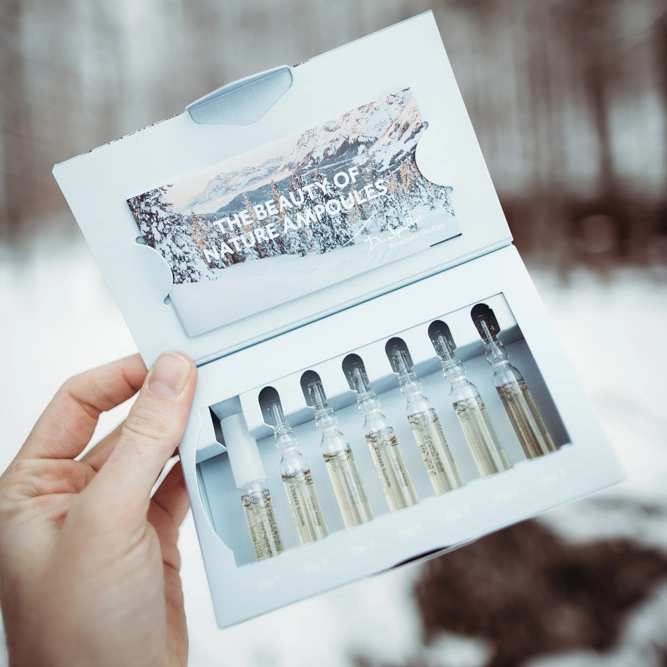 Ampoule set in opened packaging on snowy background