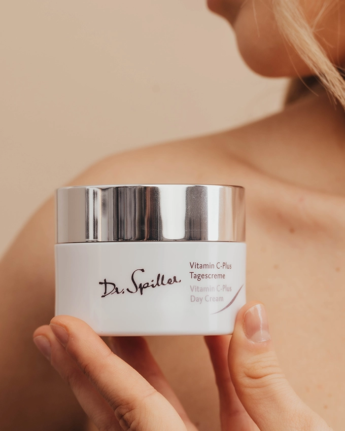 Frau hält Vitamin C Plus Tagescreme Tiegel in der Hand
