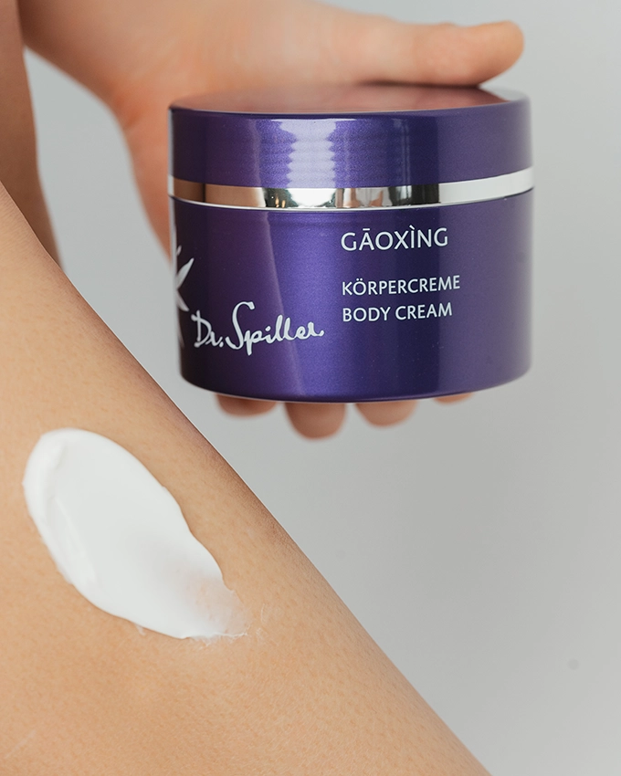 Gaoxing body cream applied to woman's leg and pictured next to it