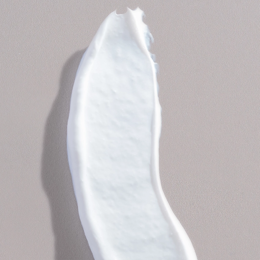 Nahaufnahme Textur - weiße Jojoba Peeling Creme mit Peelingkörnern