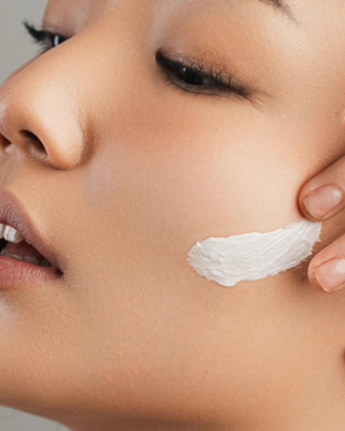 Auftragen der Gesichtspflege auf der Wange