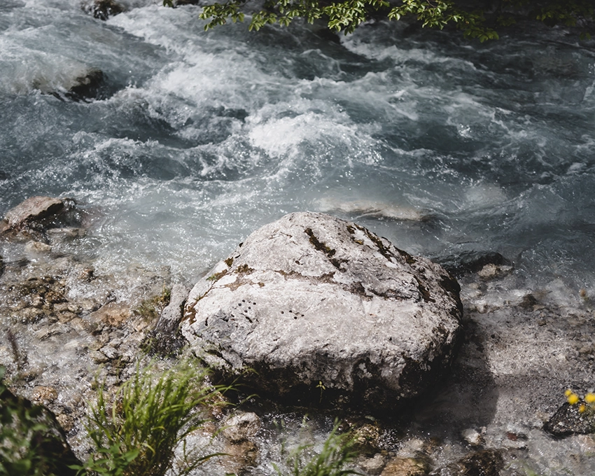 Großer Stein am wilden Gebirgsbach mit sprudelndem Wasser
