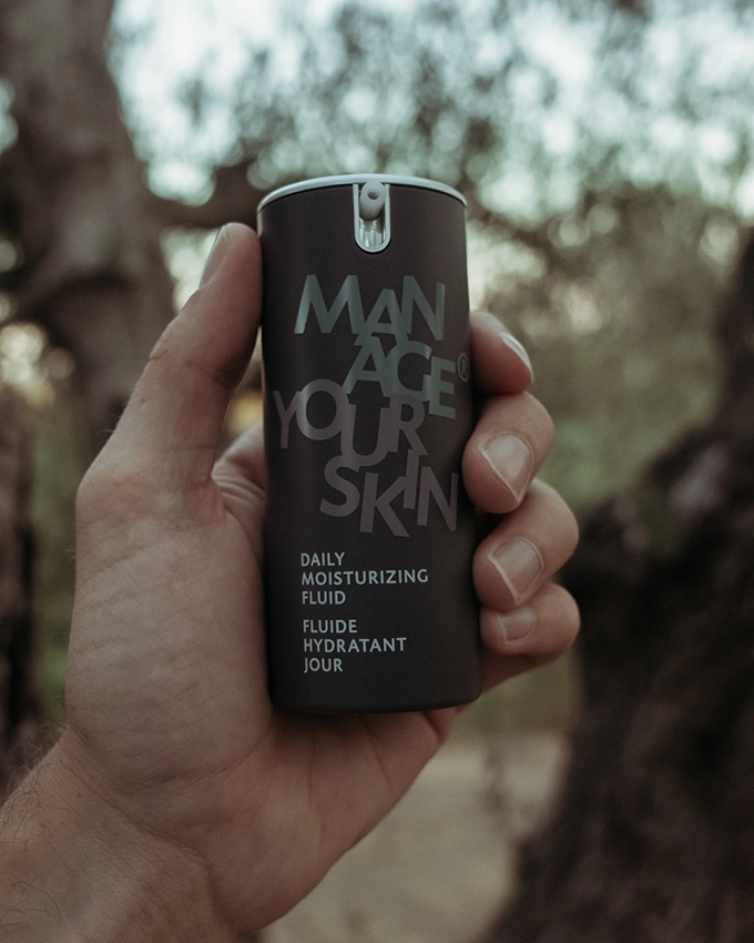 Daily Moisturizing Fluid is held in the air in nature