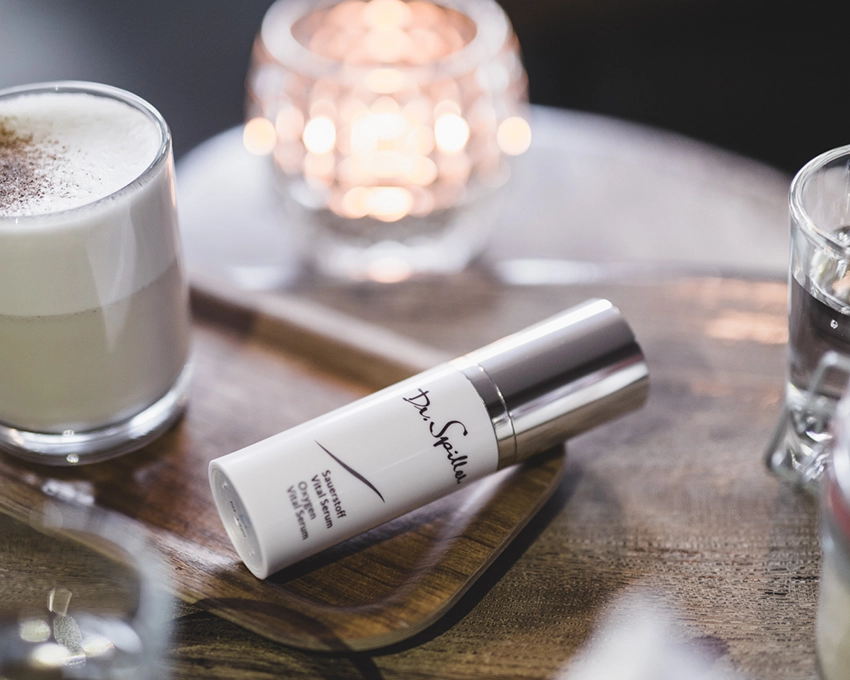 Sauerstoff Vital Serum liegt neben einem Milchkaffee auf einem Tisch