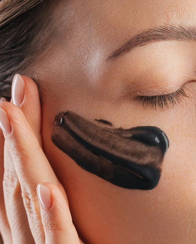 Woman applies Purification Mask to her face