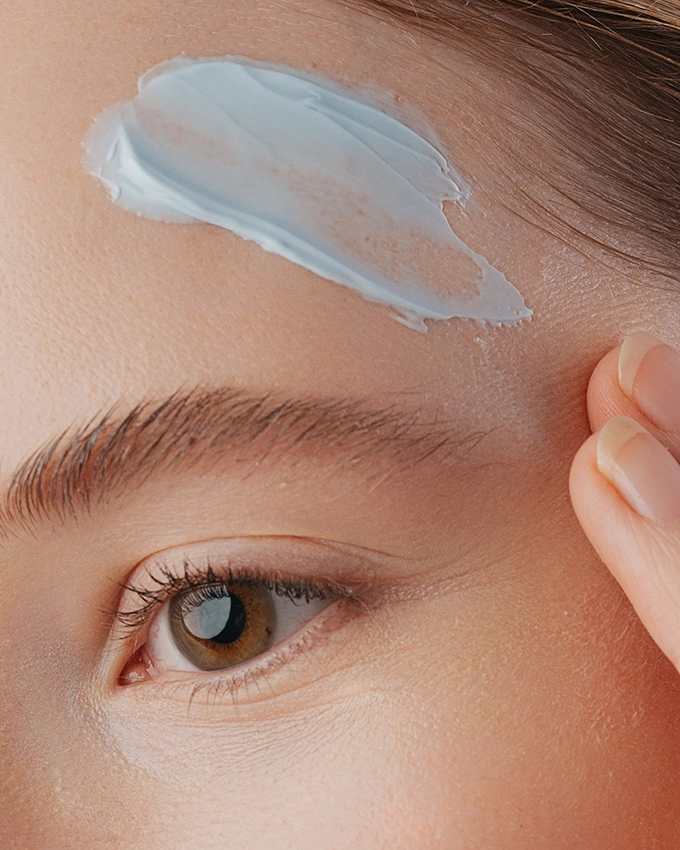 Gesichtscreme auftragen auf der Stirn