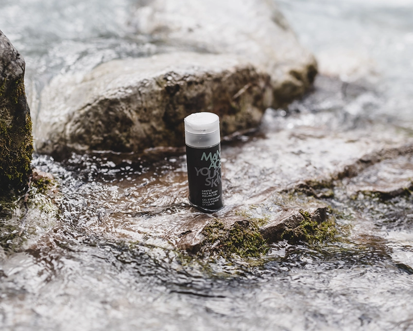 Gentle Face & Body Peeling Gel placed on a stone with running water