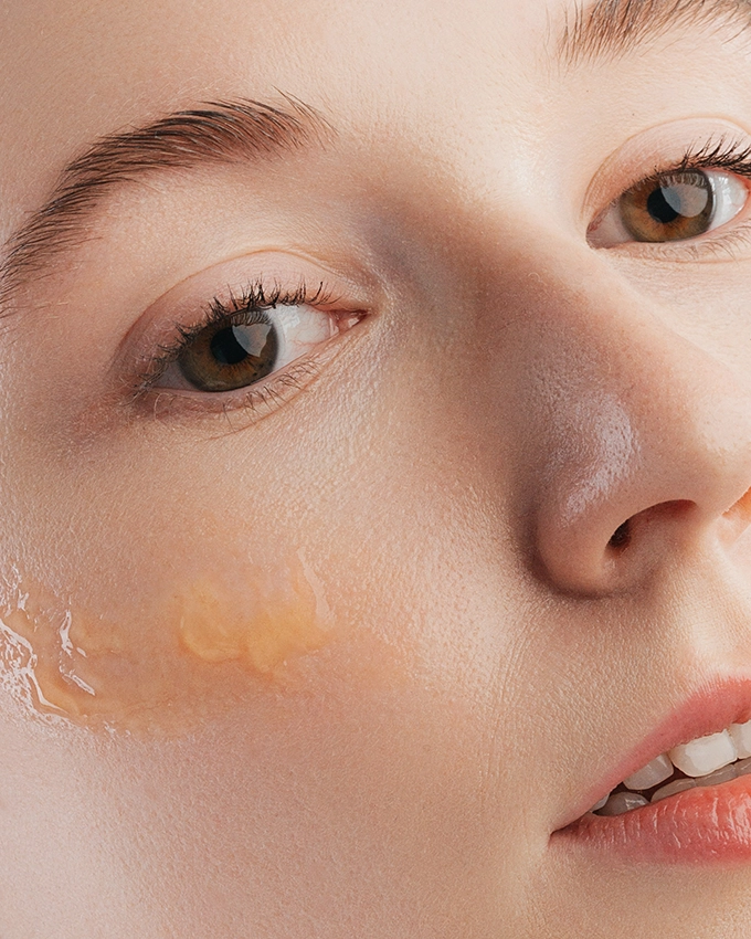 Serum wird auf Wange von Frau aufgetragen