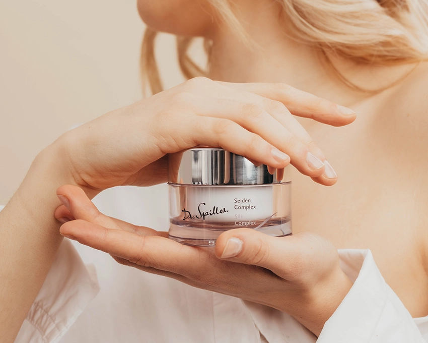 Woman holding a Dr. Spiller face care jar in two hands